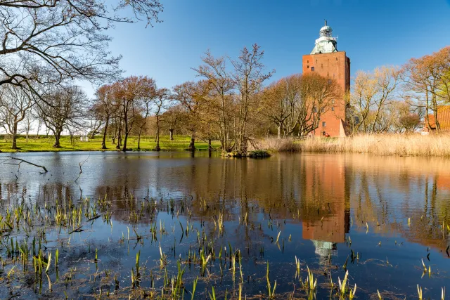 The lighthouse is reflected in the pond of the Herrengarten