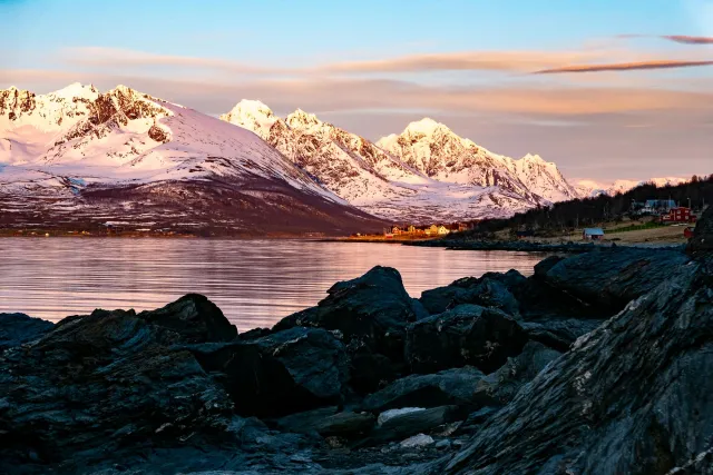 The reflection of the Lyngen Alps in Sør-Lenangen Bay and the now golden shimmering village of Lenangsøyra.