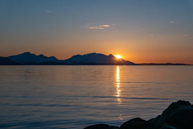 Die Mitternachtssonne über der Insel Reinøya im Ullsfjord in Norwegen