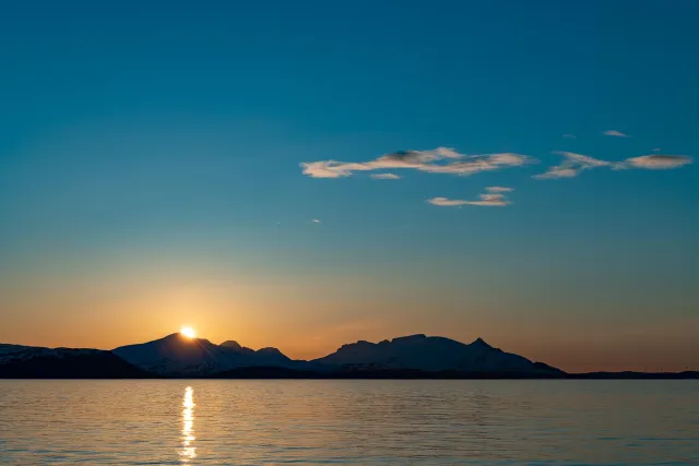 Die Mitternachtssonne über der Insel Reinøya im Ullsfjord in Norwegen